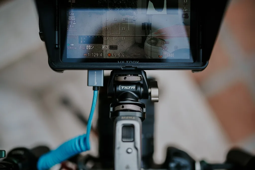 Viltrox on-camera monitor on a Tilta mount displaying 4K recording settings during a video shoot