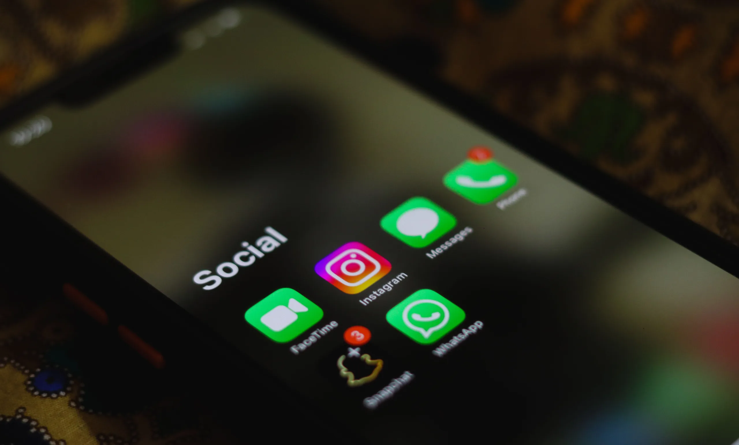 Smartphone screen showing a Social apps folder with Instagram, FaceTime, Messages, WhatsApp, Snapchat, and Phone icons